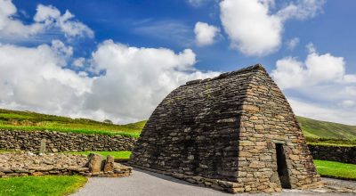 shutterstock 470786339 scaled Ancient stone building on the Slea Head drive tour from Dingle, set in a grassy rural landscape.