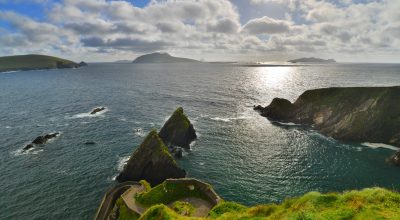 shutterstock 668864335 Sunny coastal cliffs along the Slea Head drive tour from Dingle under a partly cloudy sky.