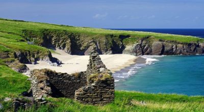 Stone ruins overlook beach and cliffs on a Wild Atlantic Way private tour Dingle.